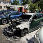 Auto fängt Feuer auf Parkplatz in Aichach – Flammen beschädigen mehrere Fahrzeuge und Plakatwand